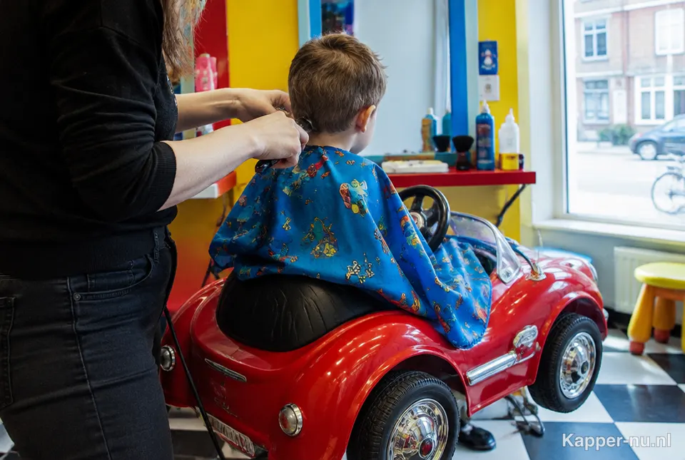 Kind wordt geknipt bij de kinderkapper